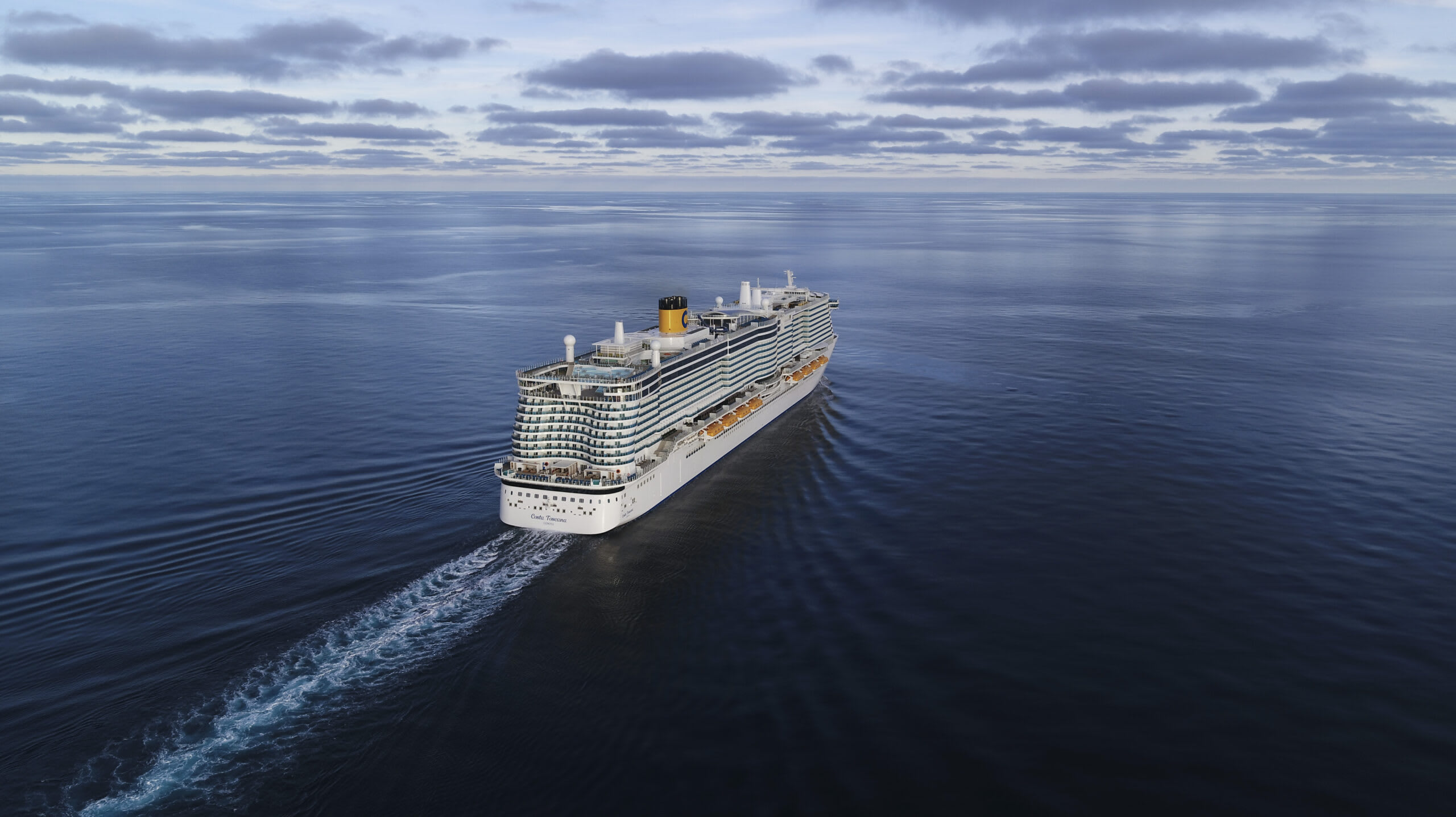 A large modern cruise ship sailing across a serene, expansive ocean under a cloudy sky.