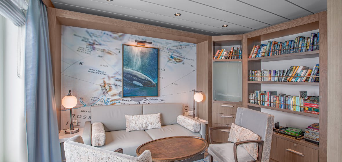 Luxury Cruise Ship Cabin with Map Wall Art A contemporary cruise ship cabin featuring elegant bedding with neutral tones and modern furnishings typical of premium cruise line accommodations.