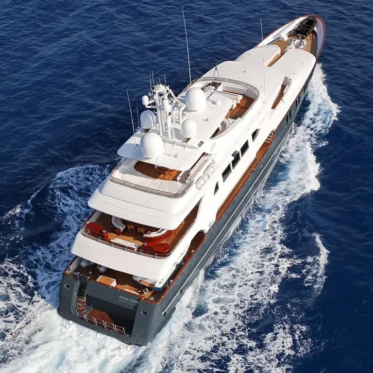 Luxury expedition yacht cruising through deep blue polar waters with dramatic scenery.