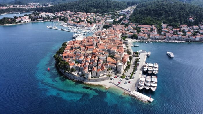 An aerial view of the historic coastal town of Rovinj, Croatia, featuring a densely packed medieval