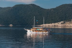 A classic wooden gulet sailing vessel with traditional Turkish design anchors in calm