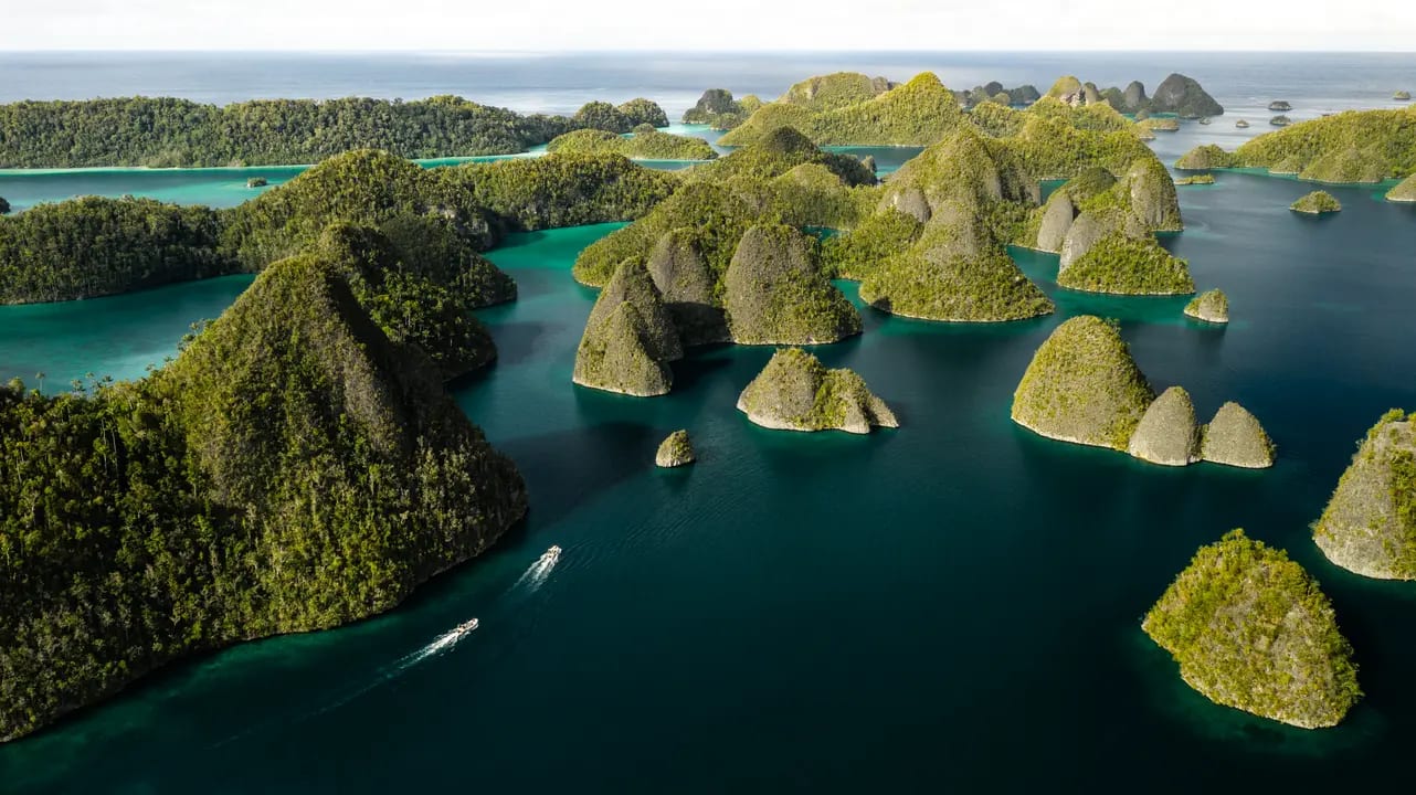 An aerial view of a stunning tropical archipelago featuring dramatic limestone karst islands