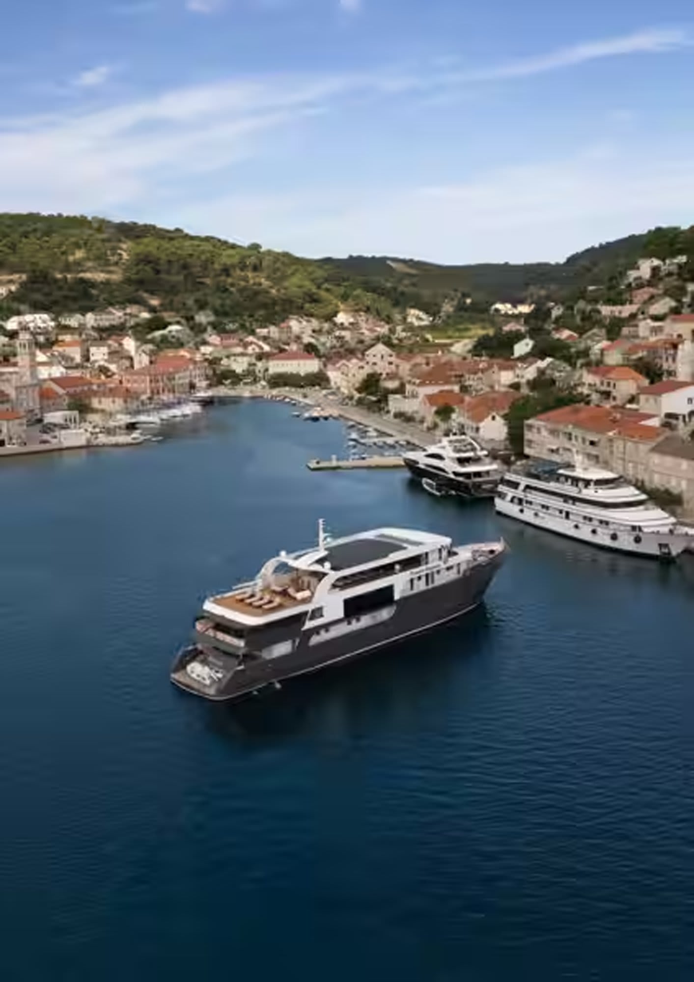Travelmarvel river cruise ship docked at a scenic European harbour with hills and traditional architecture in the background