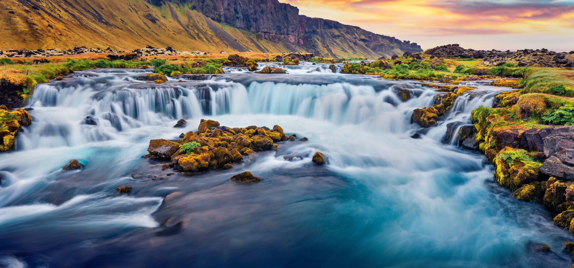A breathtaking landscape featuring multiple cascading waterfalls flowing through a pristine