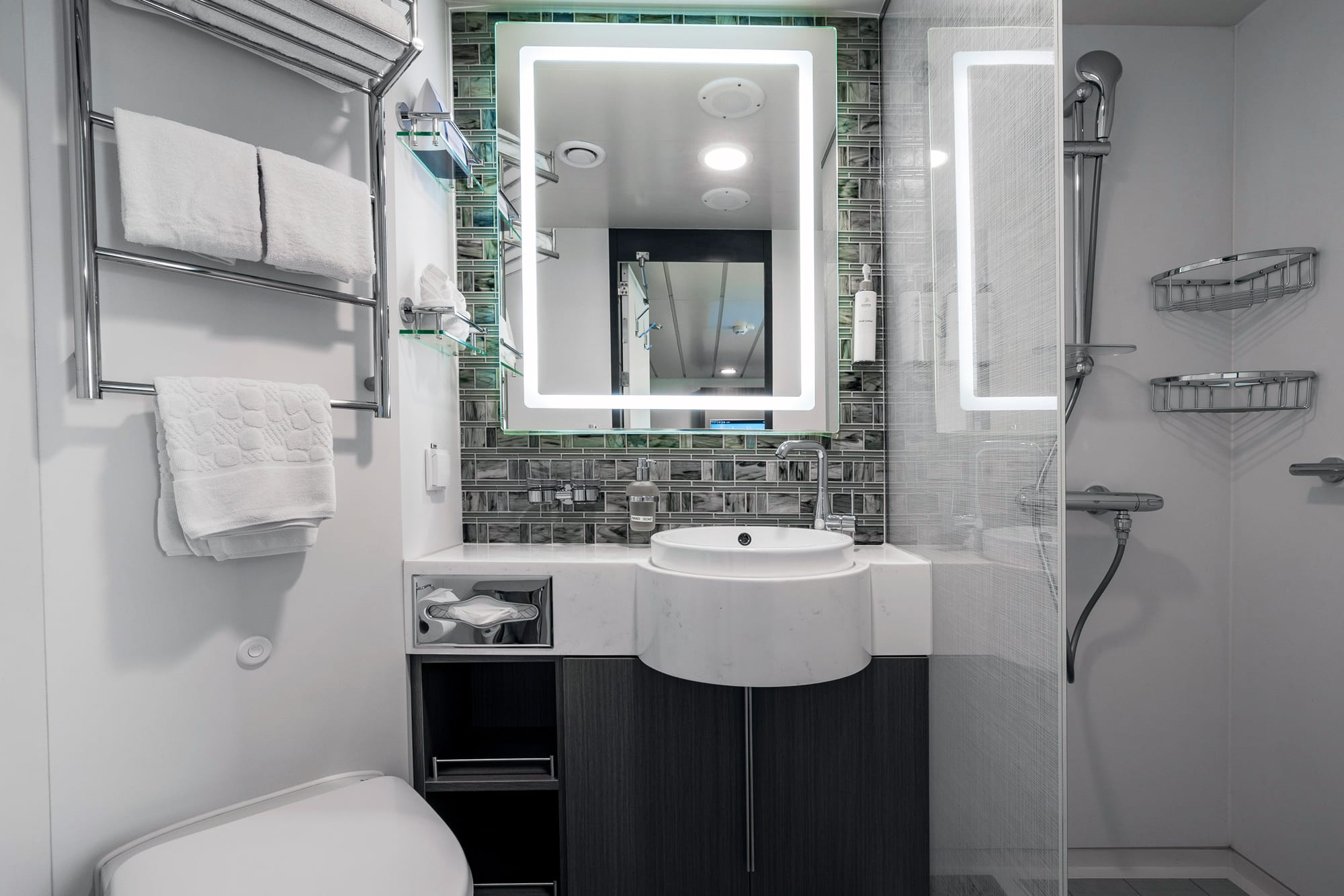 Modern Cruise Ship Bathroom with LED Mirror A contemporary bathroom aboard a cruise ship featuring a curved white sink vanity