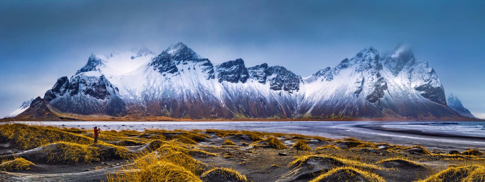 A dramatic panoramic view of the snow-capped Vestrahorn mountain range rising majestically from