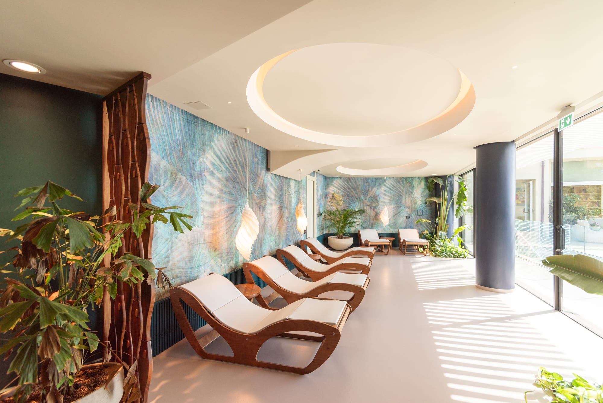 Copy of RGF_4213 Modern spa relaxation room with wooden loungers, circular ceiling lights, and tropical plants
