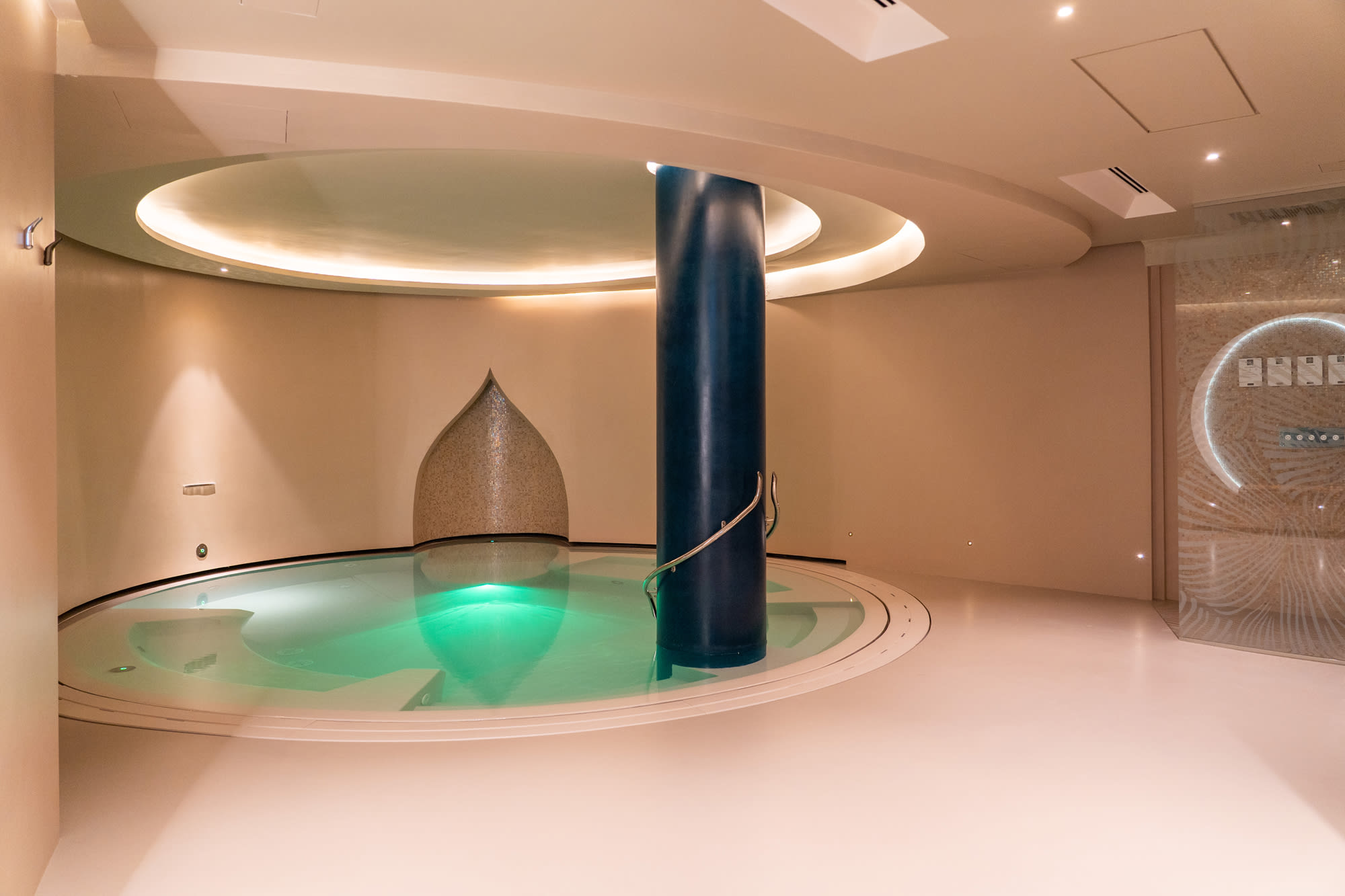Copy of _DSC2541 Modern spa pool with turquoise water and central black column, round ceiling with warm lighting