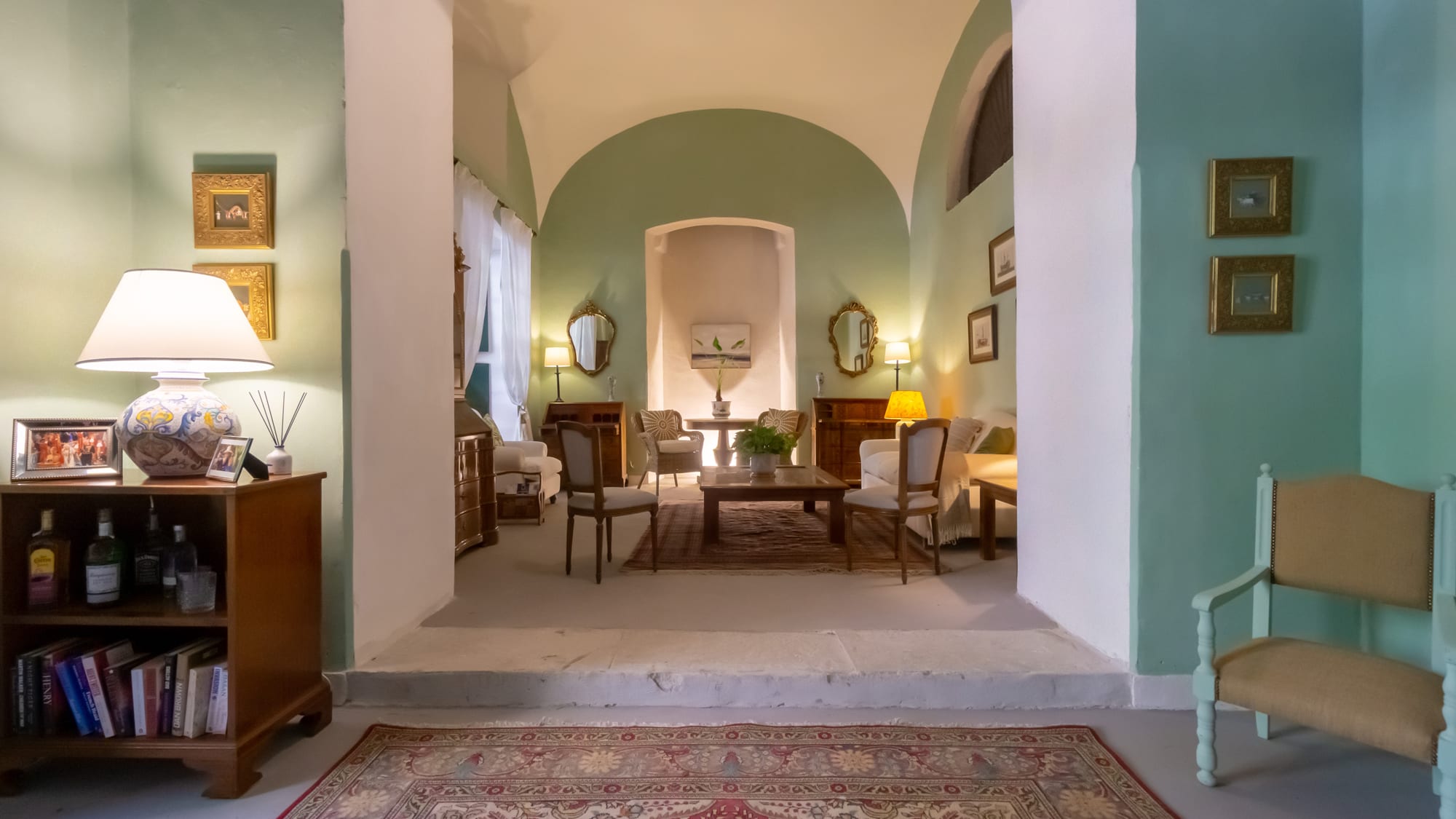 Copy of comunal sitting room Elegant hotel lobby with arched ceiling, wood furniture, and soft lighting throughout spacious room