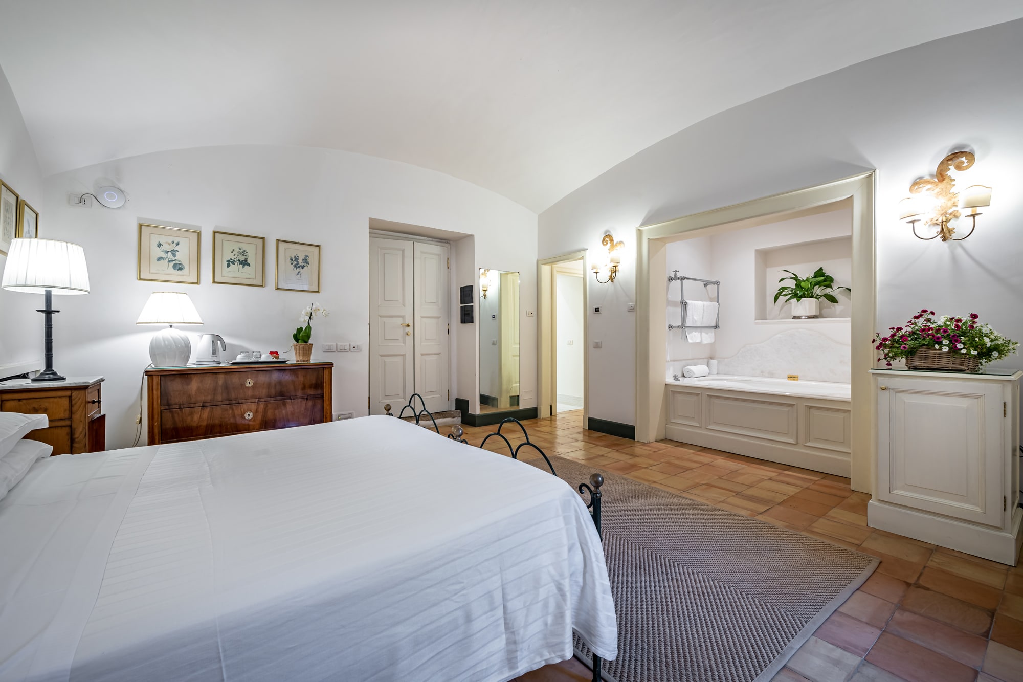 Copy of standard casa Edoardo 192 Luxurious hotel bedroom with arched ceiling, wooden furnishings, and ensuite bathroom visible