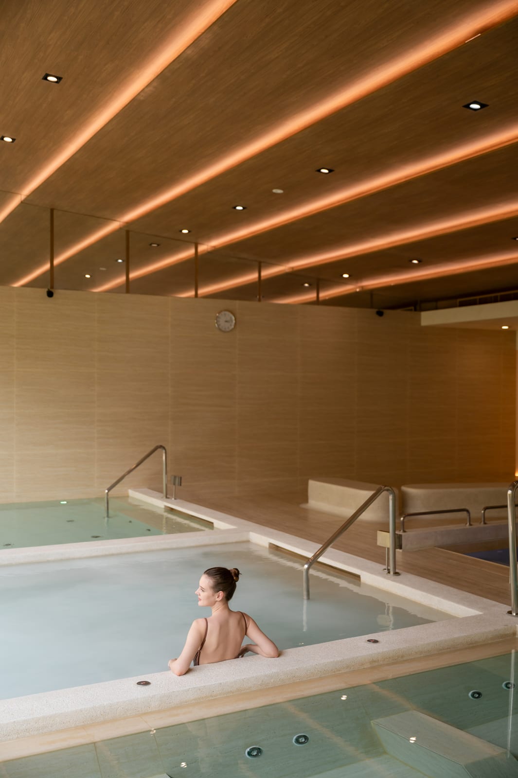 RXV Oxygen Bath(1) Woman relaxing in spa pool with warm ambient ceiling lighting