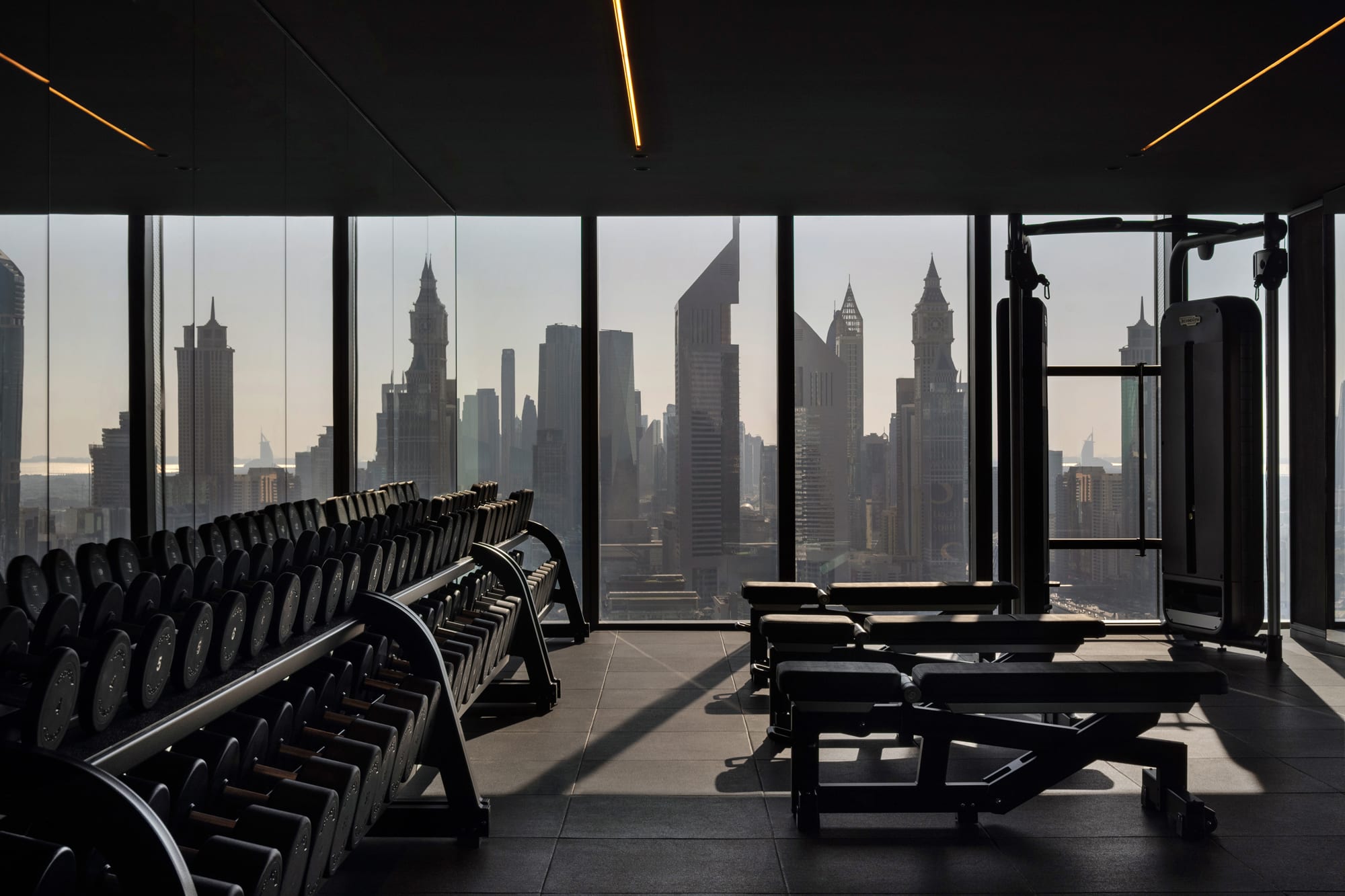 Siro Hotel Modern gym with floor-to-ceiling windows overlooking Manhattan skyline and skyscrapers