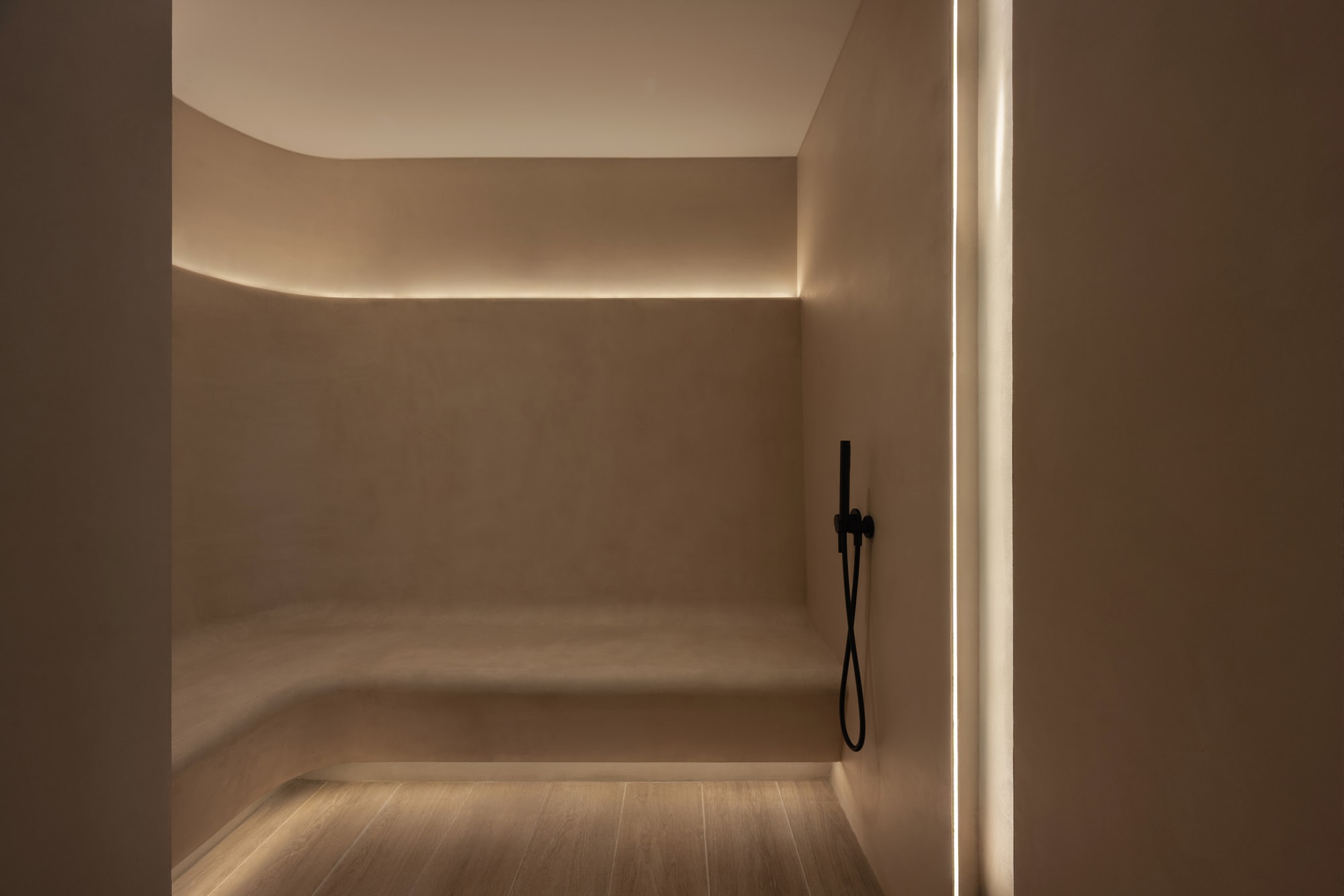 Siro Hotel Modern bathroom with minimalist design, recessed ceiling lighting, and black handheld showerhead