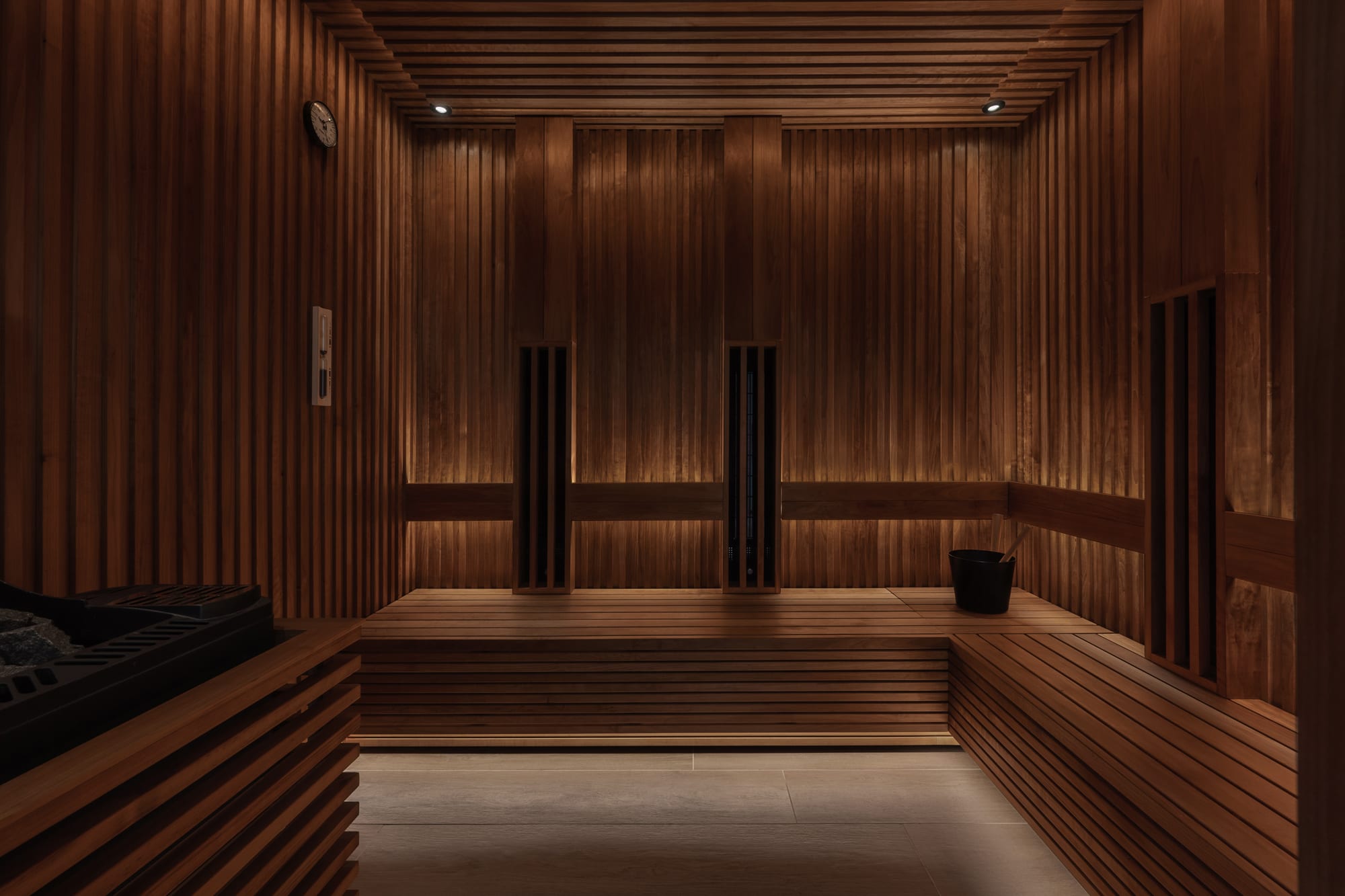 Siro Hotel Modern sauna interior with wood paneling, tiered benches, and glass doors
