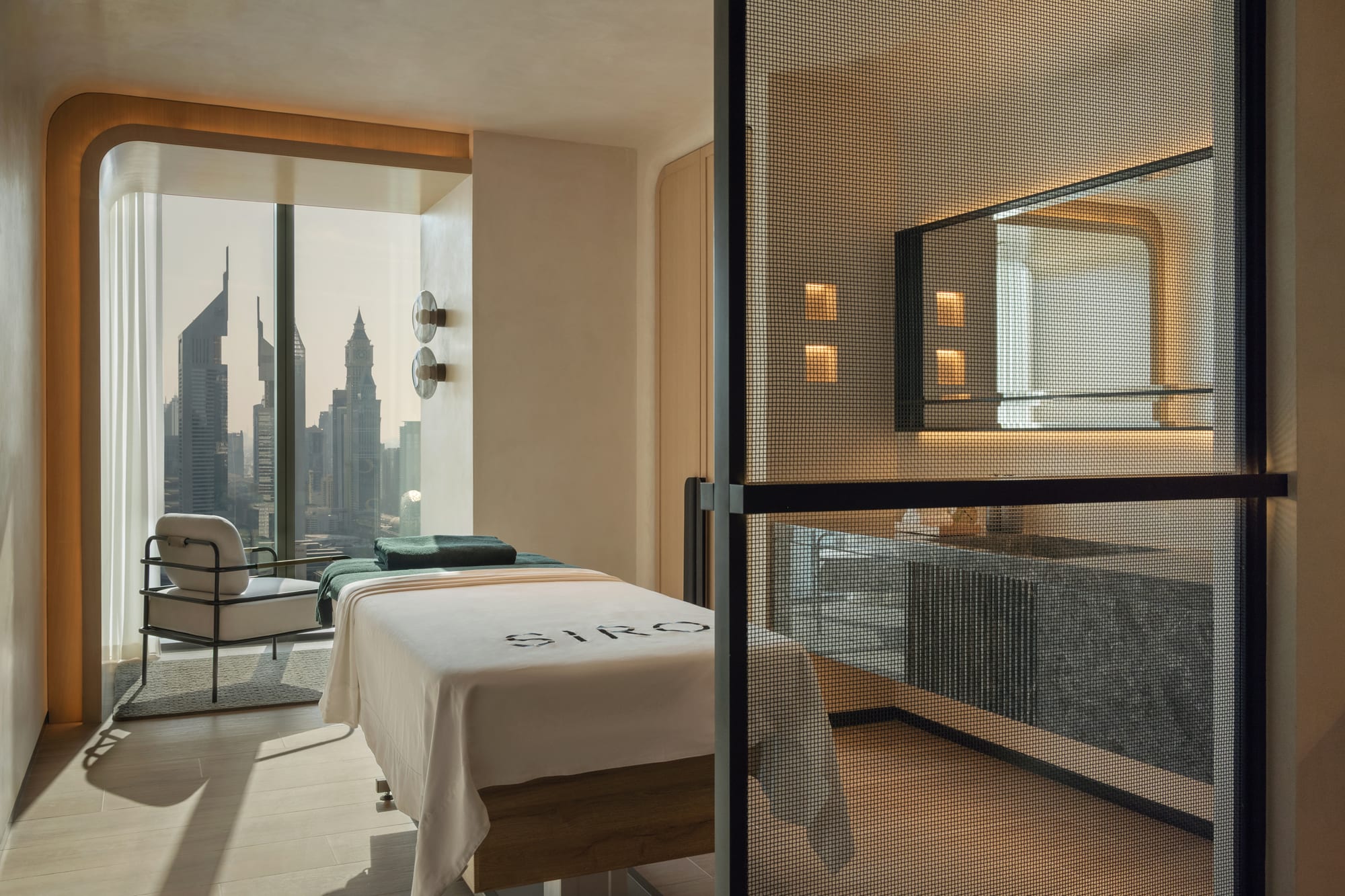 Siro Hotel Modern hotel bedroom with floor-to-ceiling windows overlooking Manhattan skyline and iconic skyscrapers
