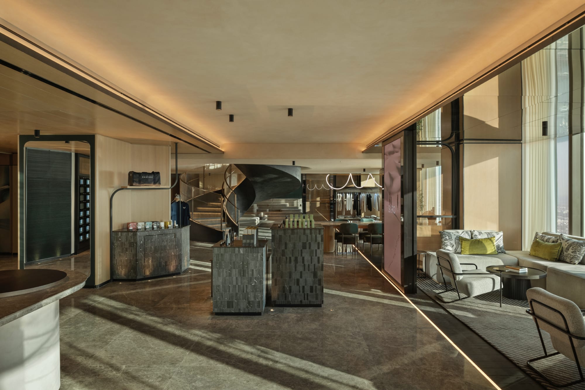 Siro One Zabeel, Siro Hotels Modern luxury retail space with textured display fixtures, seating area with green cushions, and floor-to-ceiling windows