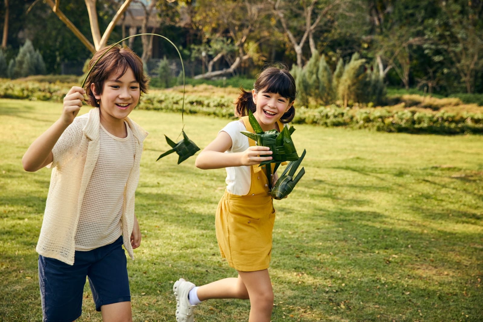 Traditional Thai Woven Fish (Pla Tapian) Two children playing with traditional Thai woven fish toys in a garden