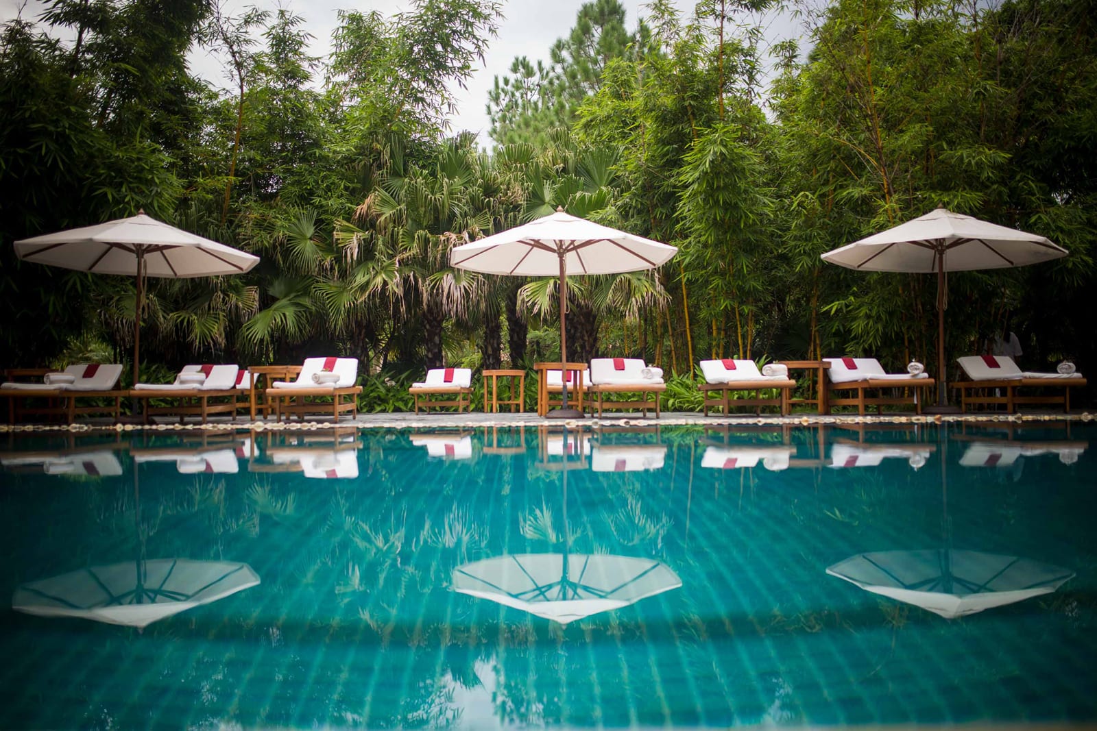 Wellness_Spa pool 2 Luxury resort pool with white umbrellas, lounge chairs, and tropical garden backdrop