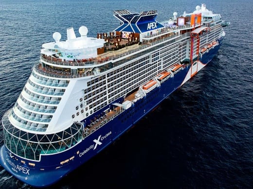 Large cruise ship with blue hull and white superstructure in ocean waters