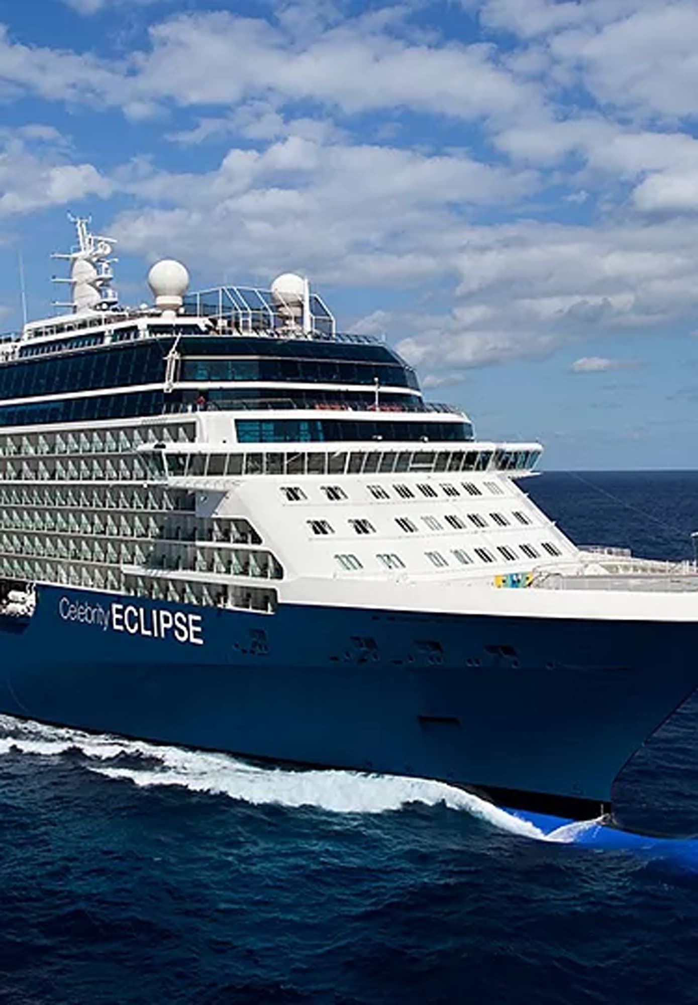A modern Celebrity Cruises Eclipse-class cruise ship sailing on blue ocean waters under a cloudy