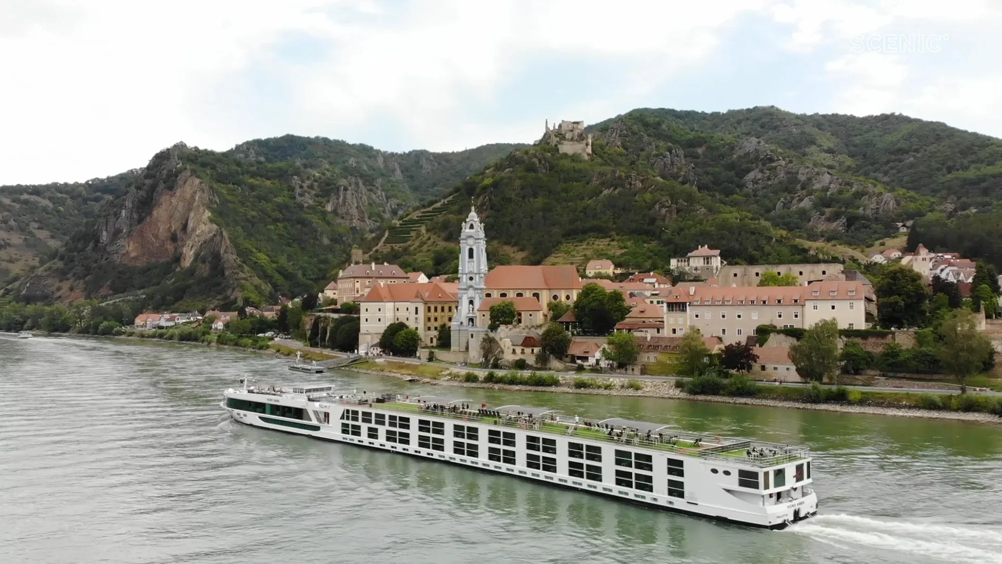 Scenic river cruise ship sailing along the Danube past a picturesque historic town