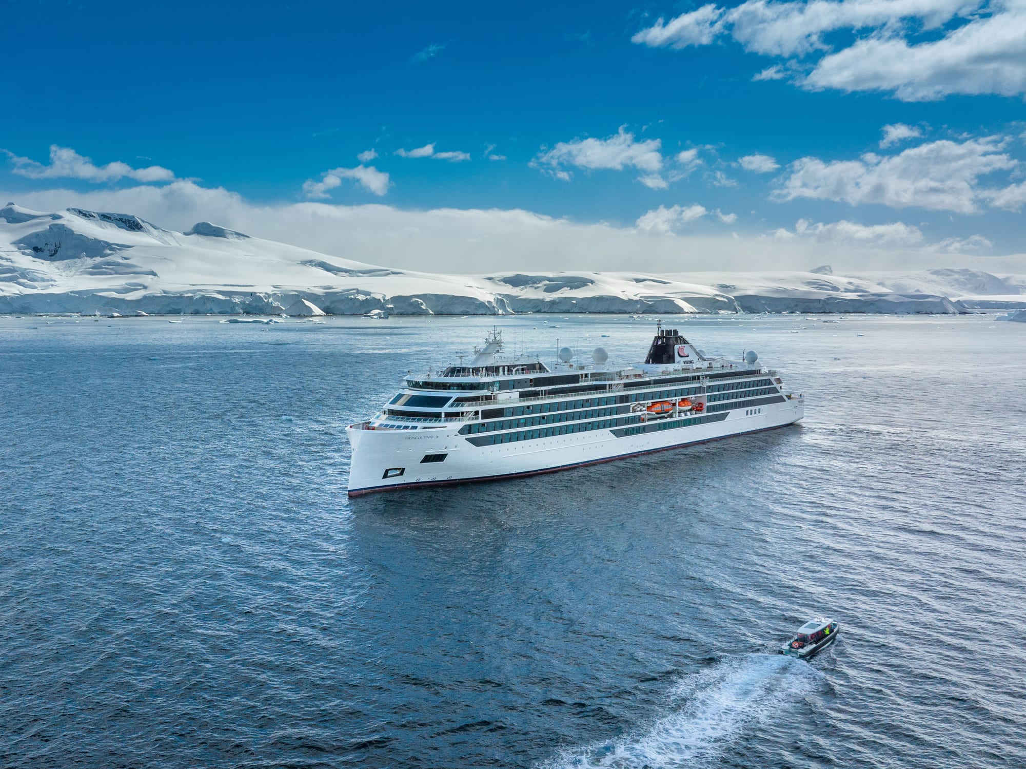 Viking expedition cruise ship navigating through Antarctic waters with glaciers in background