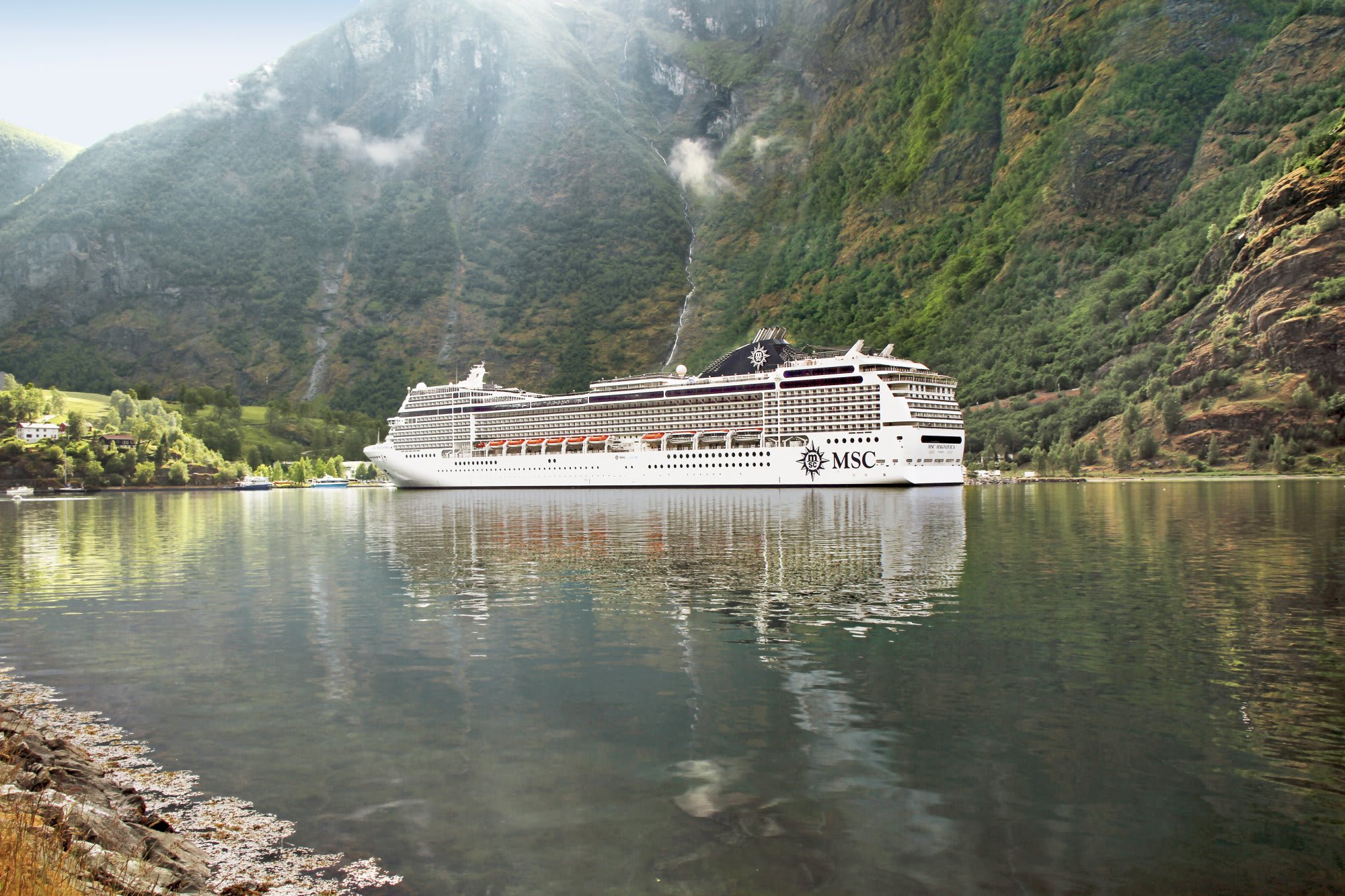 MSC Cruise Ship in Norwegian Fjord MSC cruise ship sailing through a dramatic Norwegian fjord surrounded by steep mountains