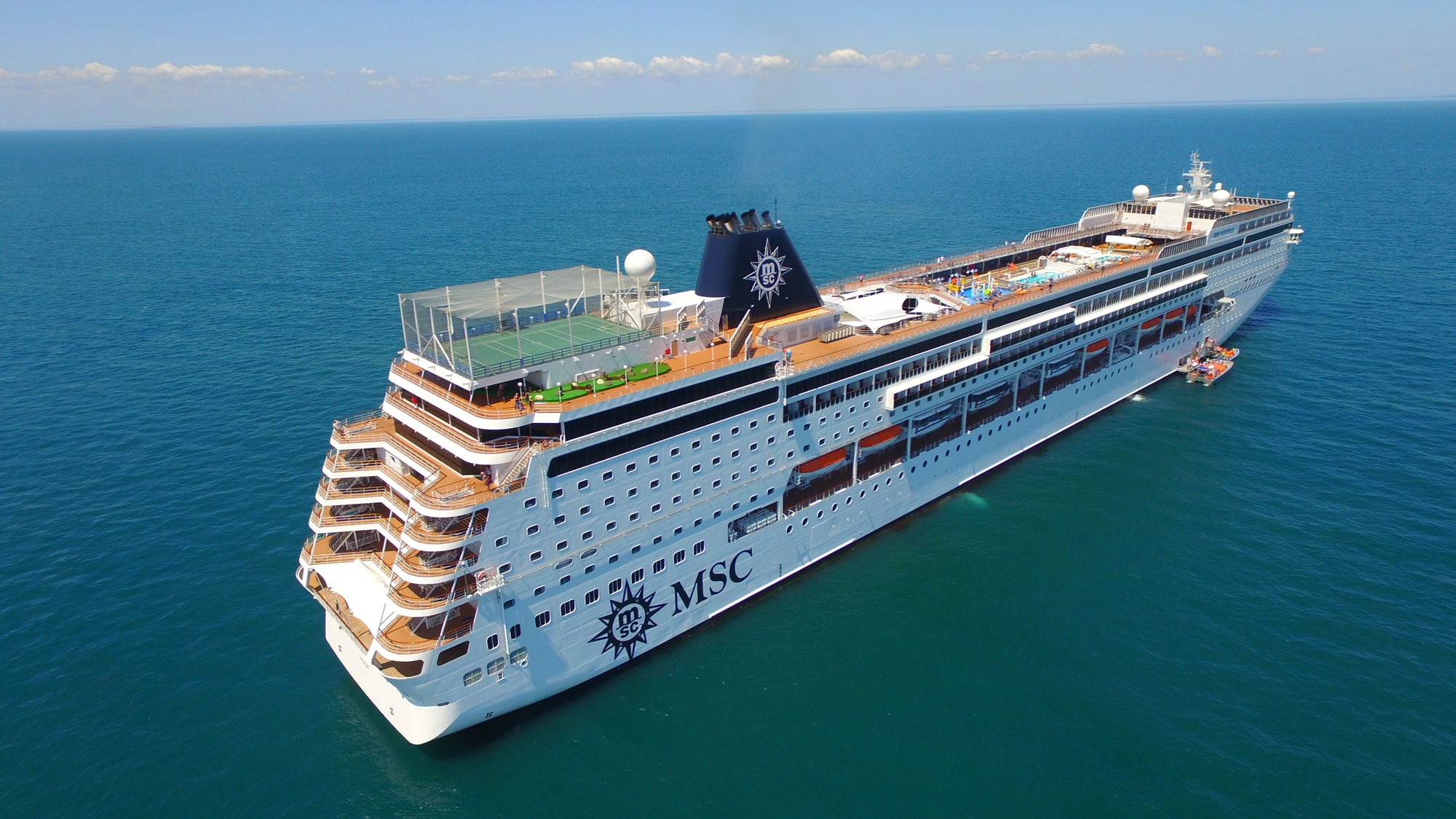 MSC Sinfonia Cruise Ship at Sea A large modern cruise ship with distinctive MSC branding and livery anchored in clear turquoise