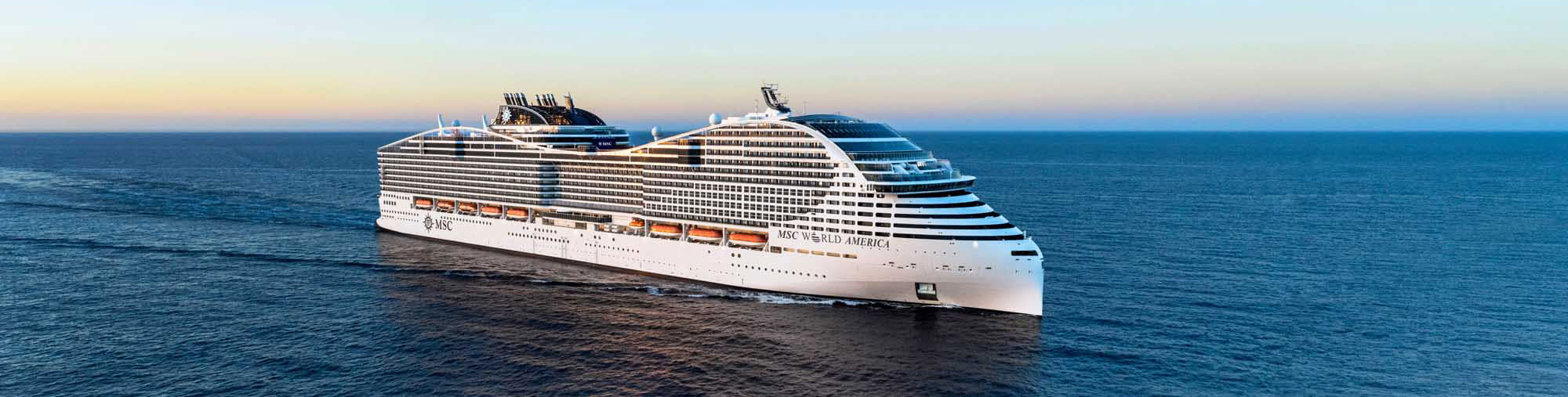 MSC World America Cruise Ship at Sea A massive modern cruise ship, the MSC World America, sails through calm blue waters during golden