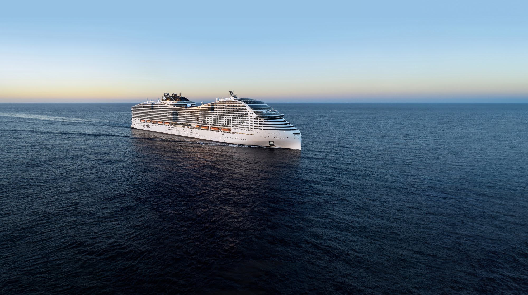 MSC World Europa Cruise Ship at Sea A modern mega cruise ship with distinctive striped hull design sailing on calm blue ocean waters
