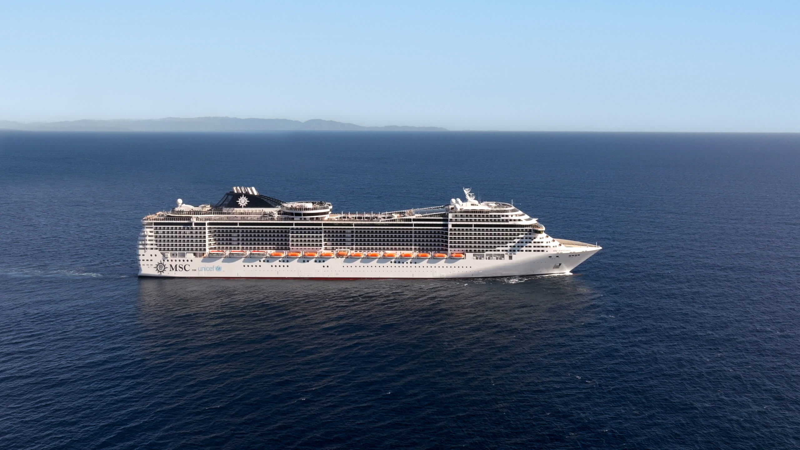 Aerials_MSC_FANTASIA.00_01_16_17.Immagine001 copy.jpg MSC Fantasia cruise ship sailing through calm blue waters