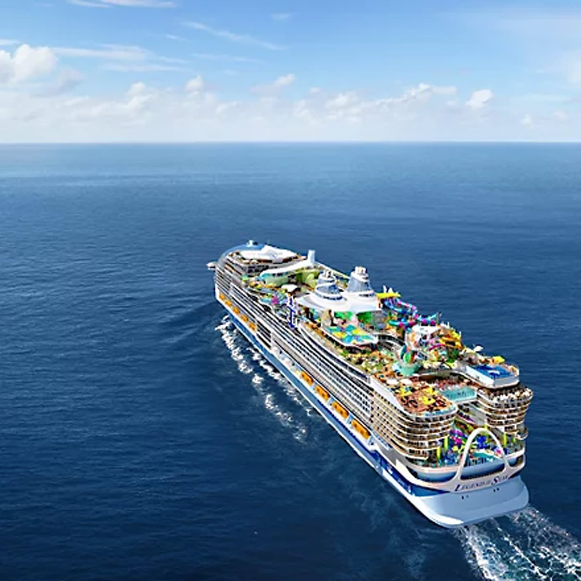 An aerial photograph of a large modern cruise ship sailing through calm blue ocean waters