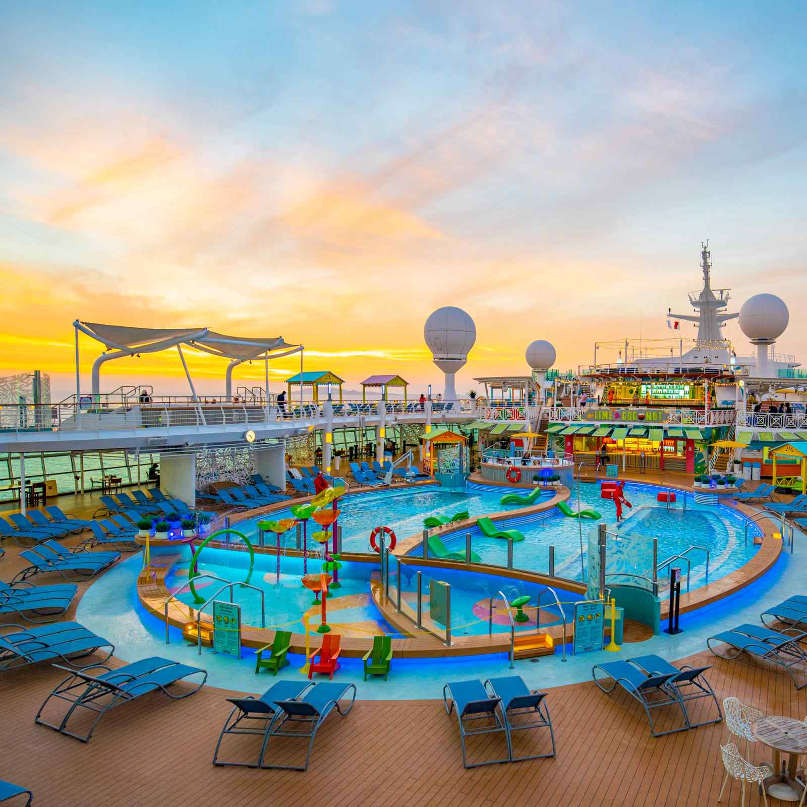 A vibrant cruise ship pool deck at golden hour, featuring multiple swimming pools with colorful
