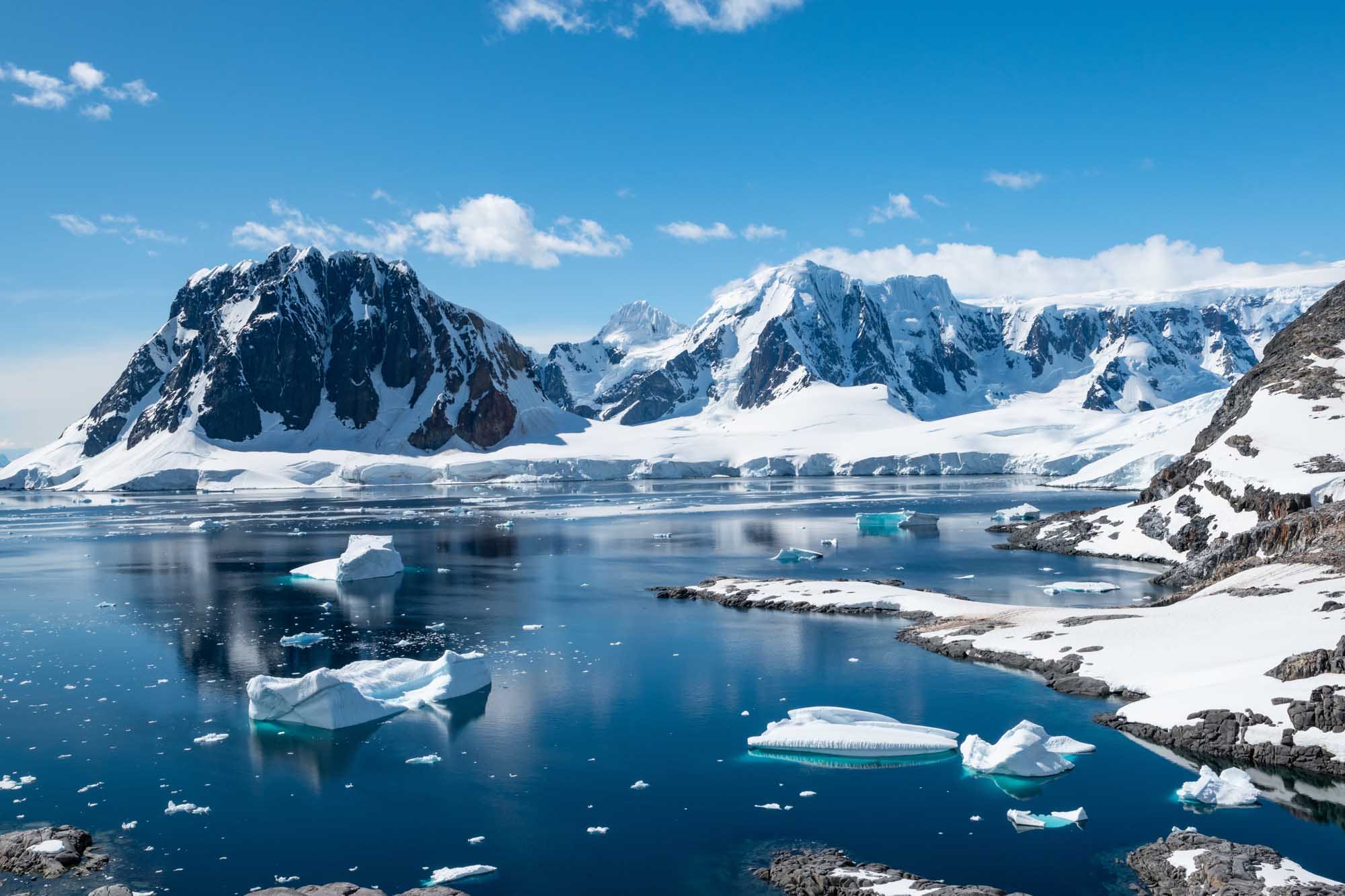 A pristine Antarctic seascape featuring Port Charcot on Booth Island, with dramatic snow-covered