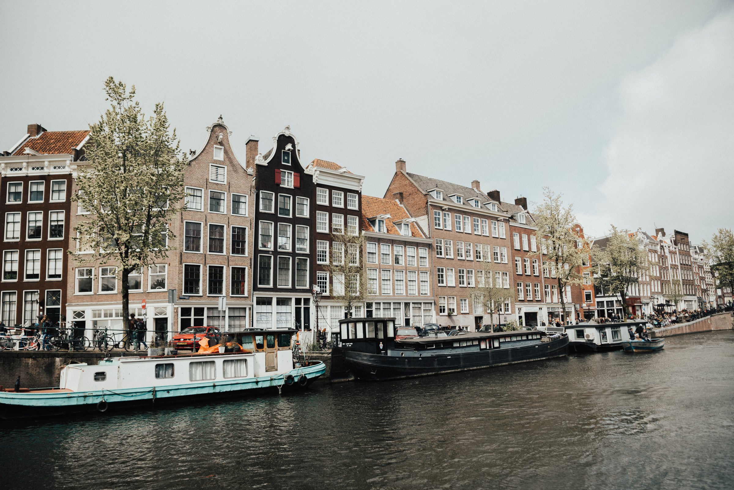 Gabled Amsterdam canal houses with houseboats moored along t Gabled Amsterdam canal houses with houseboats moored along the canal