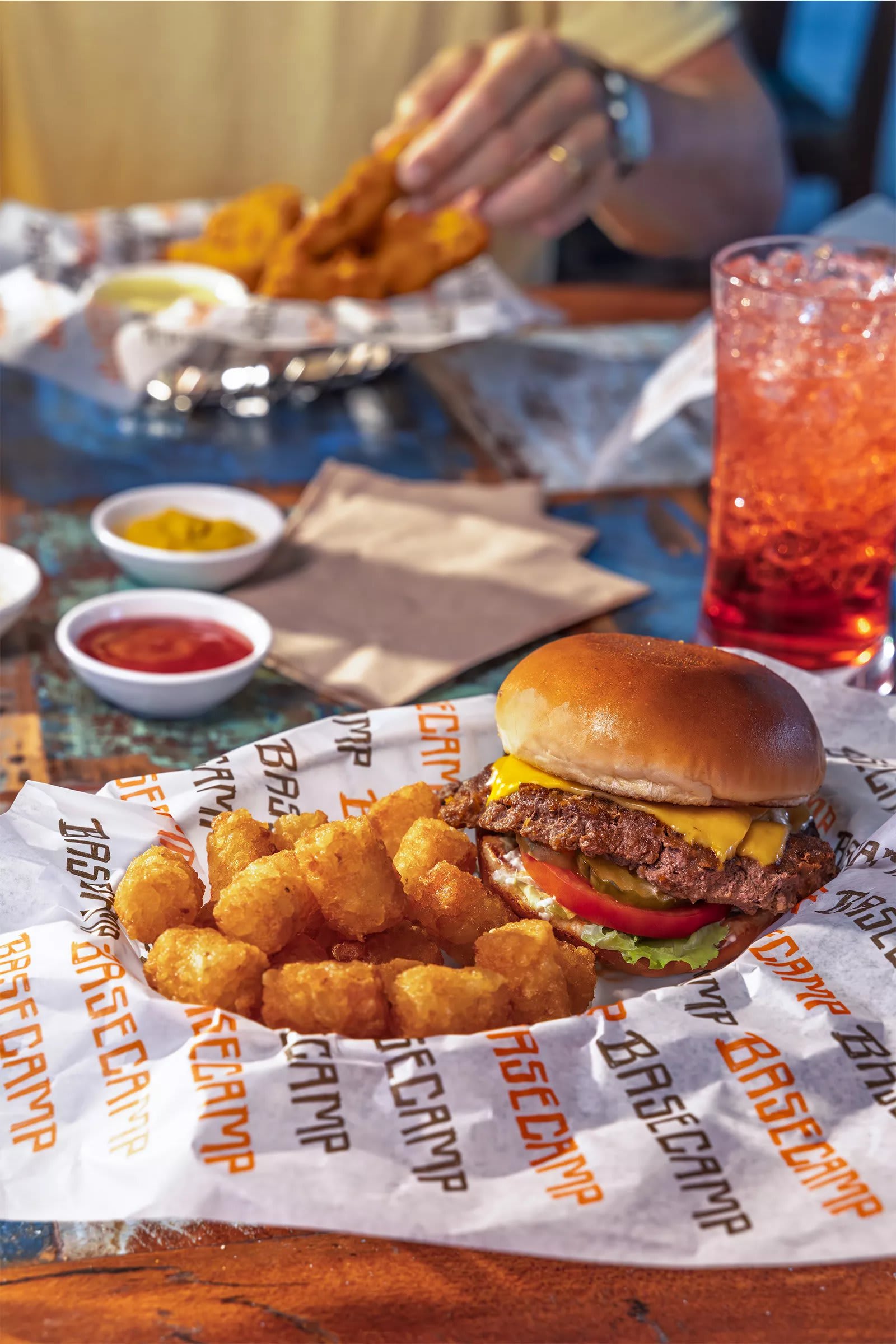 Smashburger with tater tots and chicken tenders at Basecamp