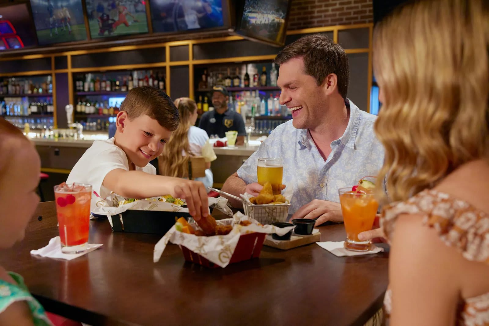 Family enjoying a meal at Playmakers Sports Bar and Arcade