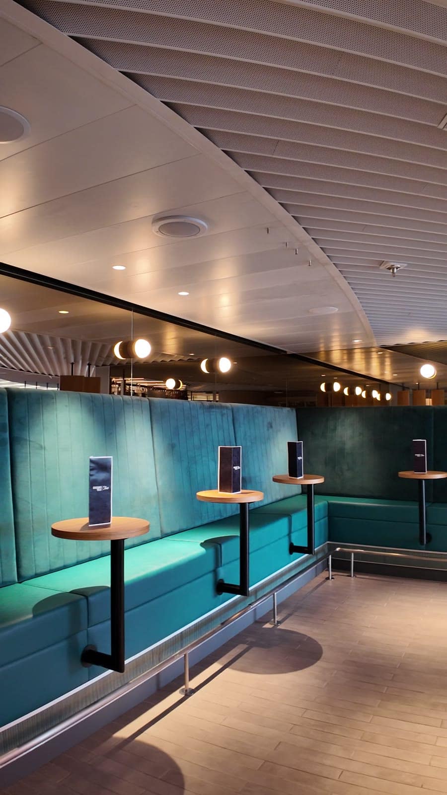 Grounds Club Too coffee bar and teal booth seating in The Galley on Valiant Lady