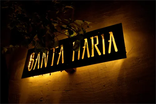 Vista frontal nocturna de la Villa Santa María, destacando el juego de luces y sombras.