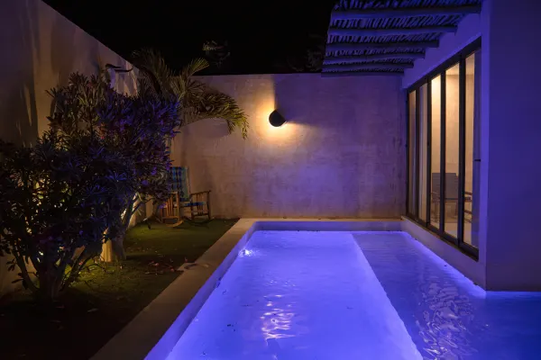 Tercera vista de la alberca de la Villa Noyollo, iluminada de noche.
