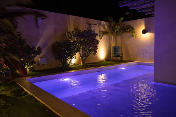 Cuarta vista de la alberca de la Villa Noyollo, iluminada de noche.