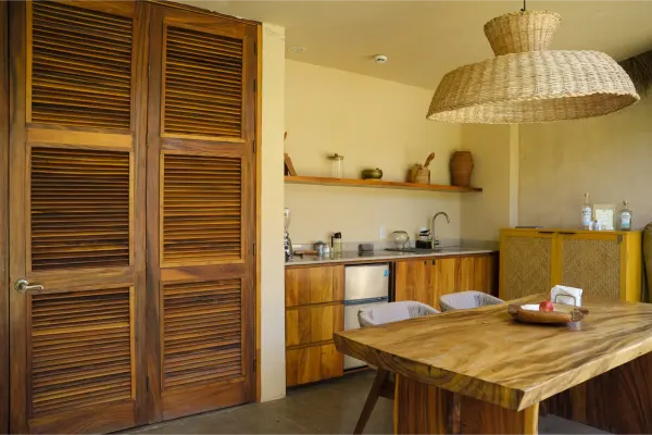 Comedor de la Villa Yahualli, con una mesa de madera y vista a los jardines.