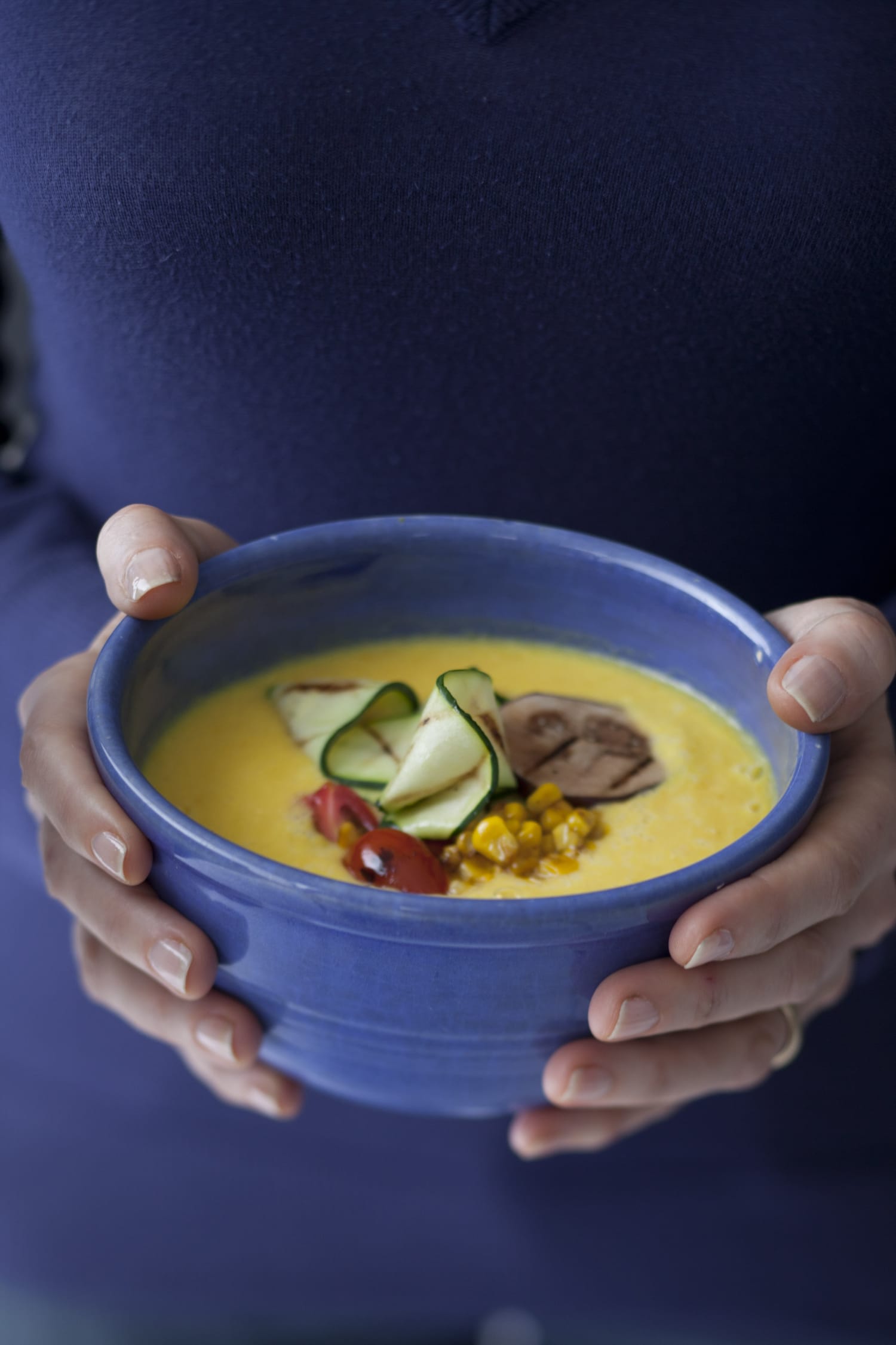A person's hands holding a bowl of soup made from ingredients grown in the White House Garden