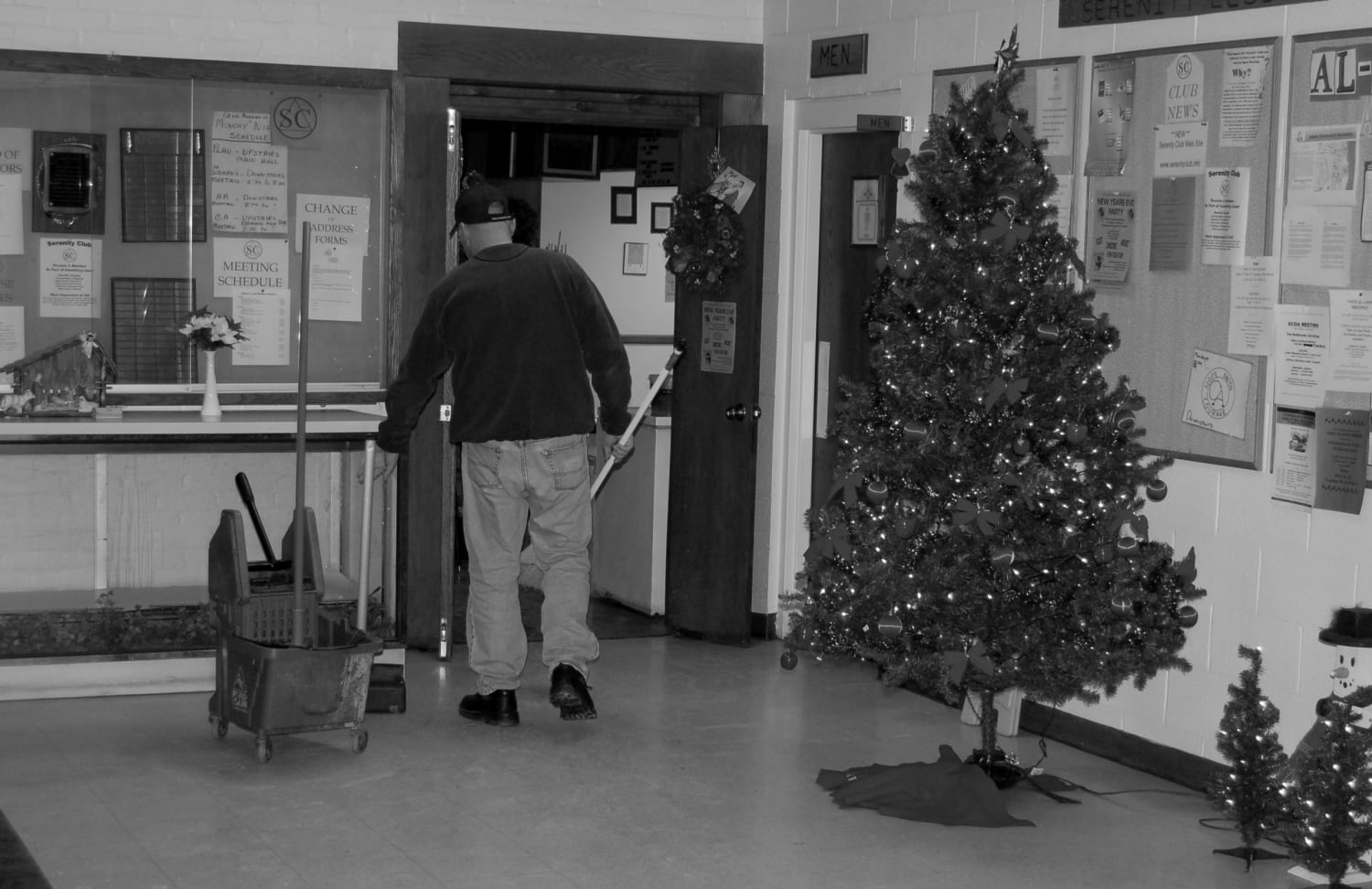 A man cleaning an office lobby at Christmas time