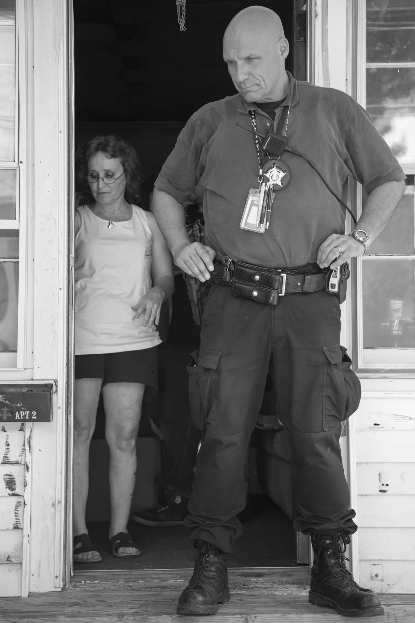 Sheriff standing outside a woman&#039;s door