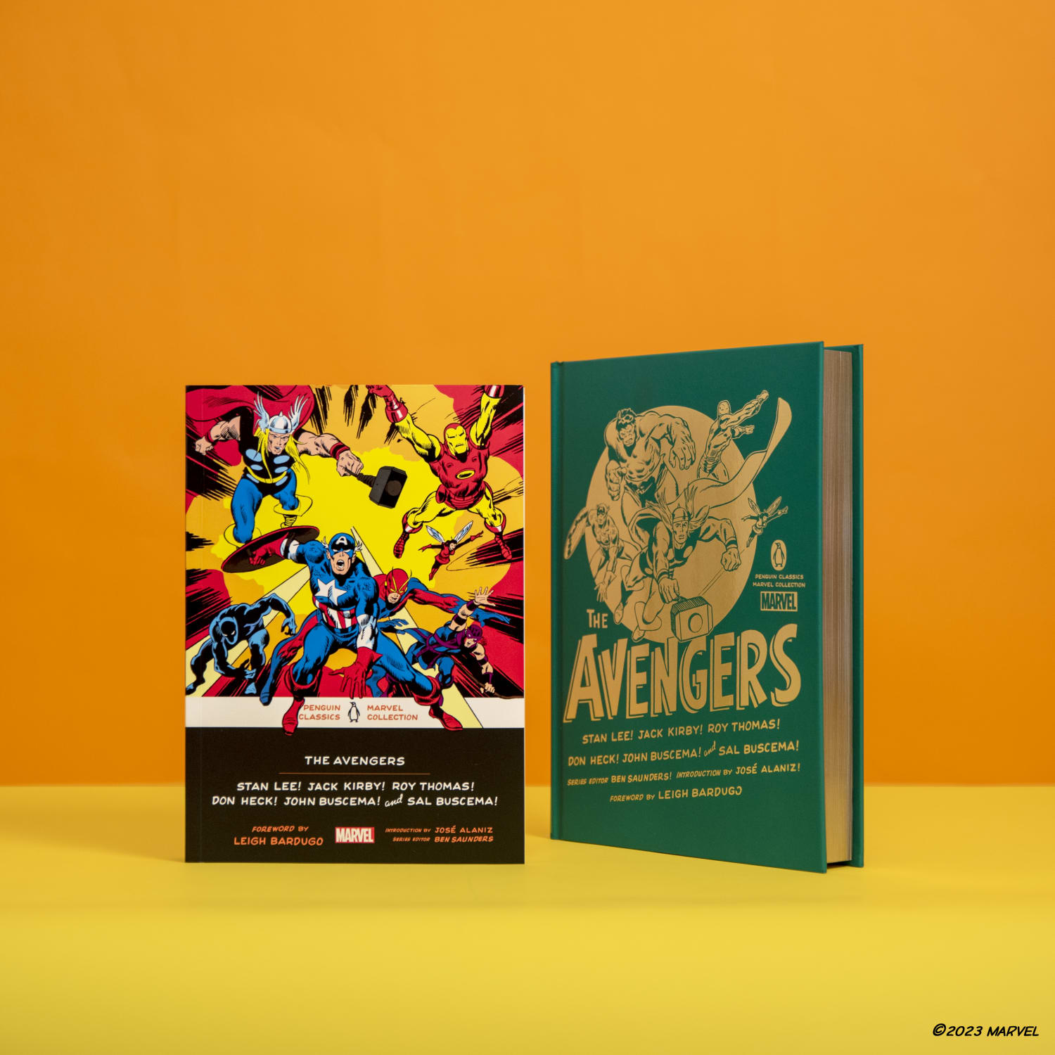 The Avengers hardcover and paperback editions standing against orange background