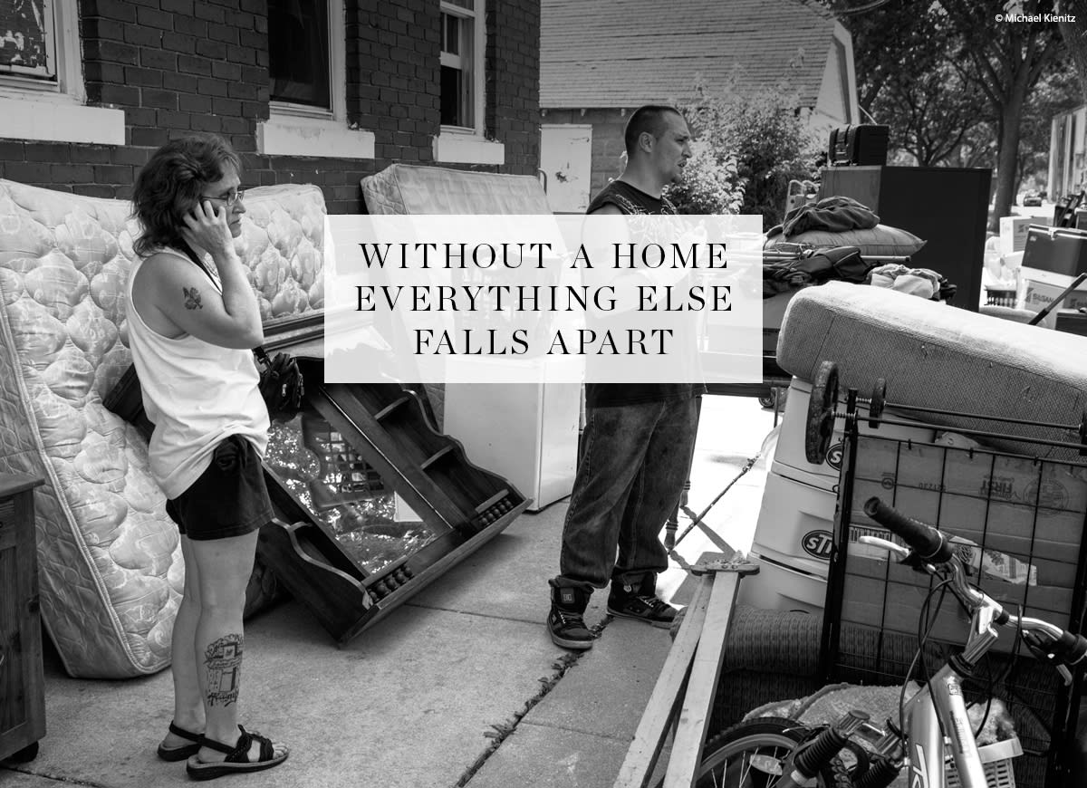 Woman and man surrounded by their belongings outside