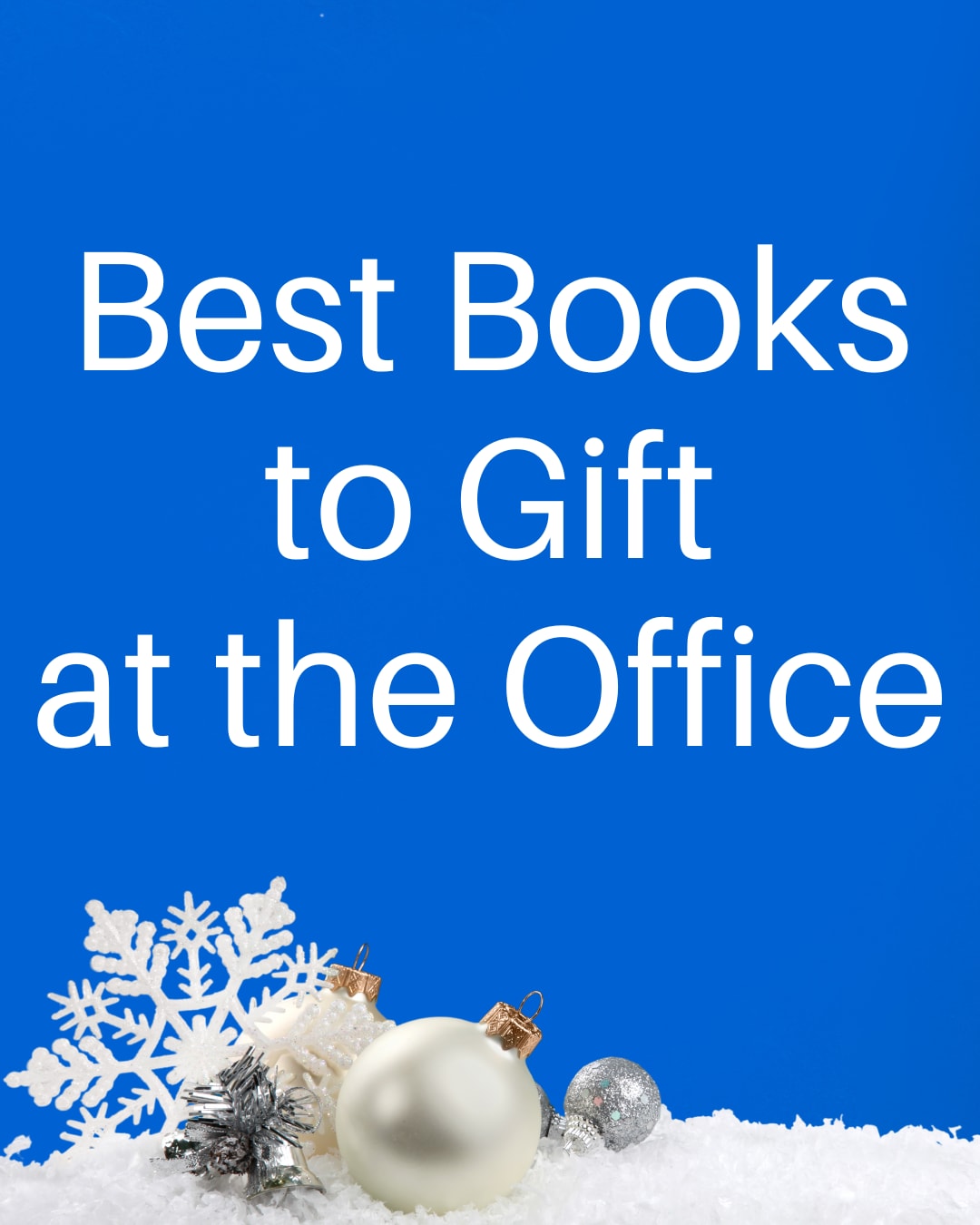 Banner showing blue background with text that reads "Best Books to Gift at the Office." To the right of the text is a laptop with a pair of hands. One hand is typing while the other is holding a mug of cocoa. There are Christmas ornaments and small pieces of green foliage scattered around the laptop.