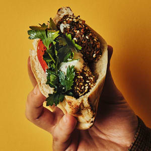 Crunchy Greeny-Beany Fritters served in a pita pocket held by Ham.