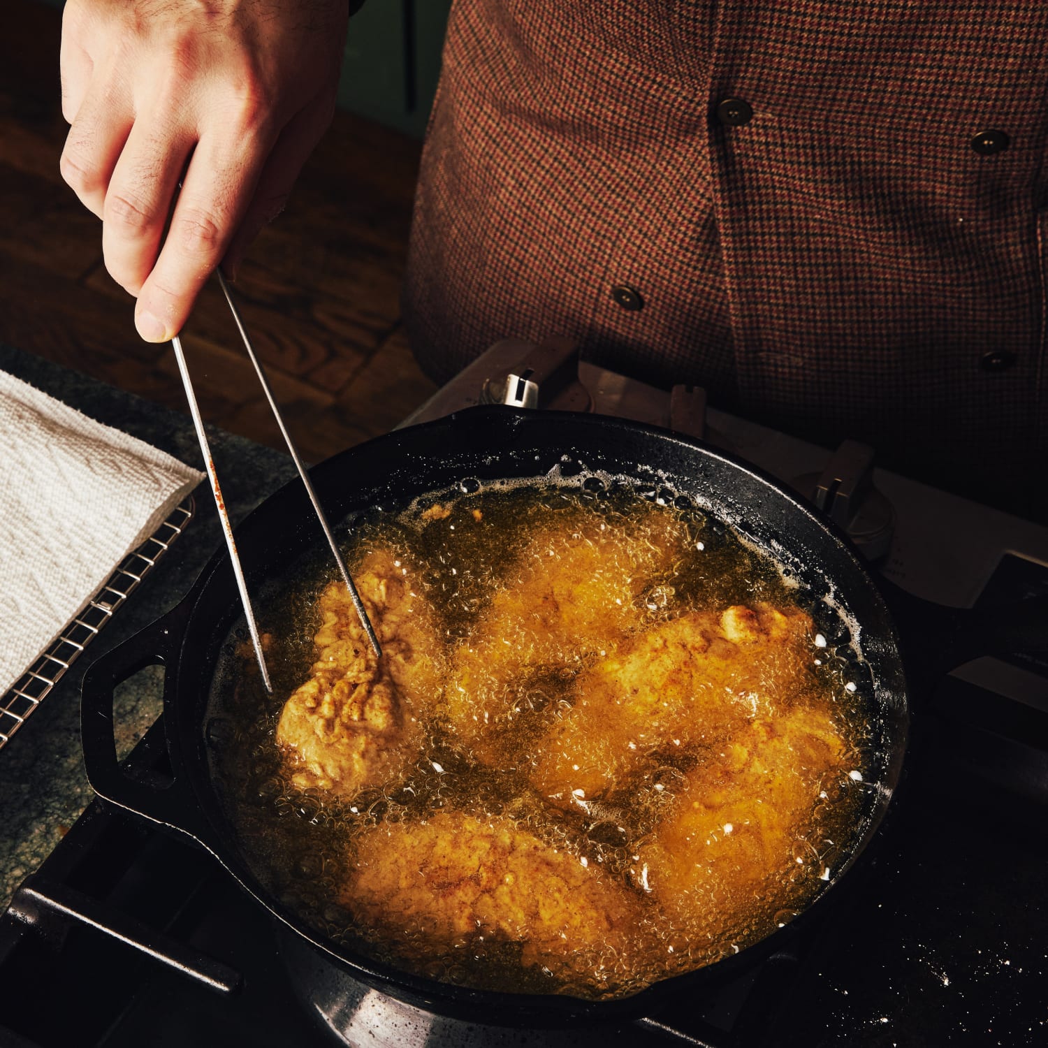 Chicken being fried in a cast iron skillet